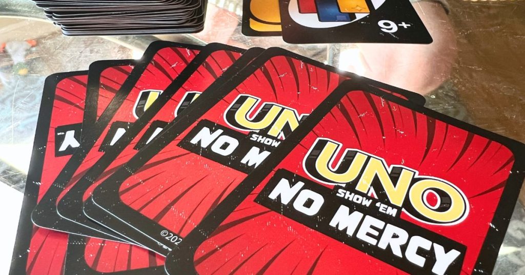 Uno No Mercy Card Game Review for Family game night or game party - uno no mercy cards spread on a table for tabletop game playing