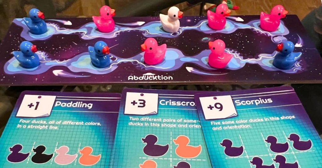 Abducktion Game Review from Game Play Graze - fun family board games with different colored duck game pieces on a small board with action cards in front